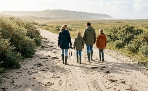 Een gezin maakt een heerlijke wandeling door de duinen op de Waddeneilanden.