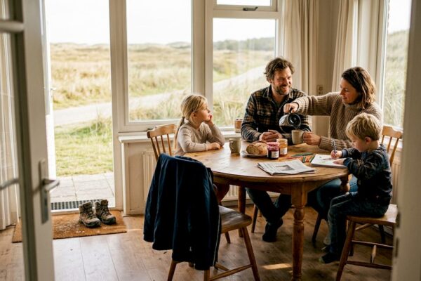 Samen genieten aan de eettafel in een gezellige vakantiewoning op de Wadden