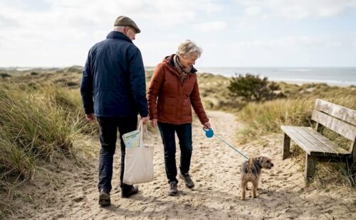 Een groep ouderen geniet samen van een wandeling langs de Waddenkust.
