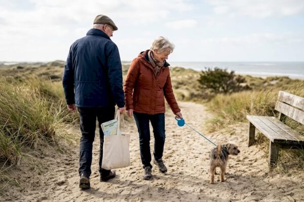 Een groep ouderen geniet samen van een wandeling langs de Waddenkust.