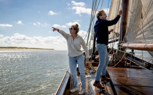 Stel geniet van een zeiltocht langs de Waddeneilanden