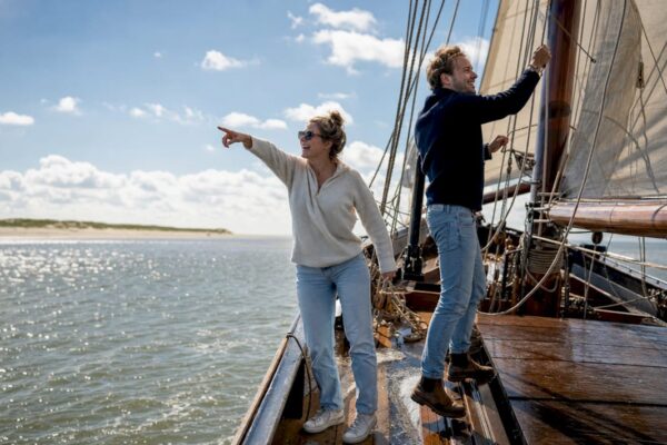 Stel geniet van een zeiltocht langs de Waddeneilanden