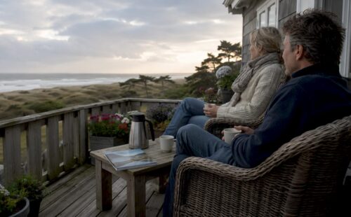 Stelletje geniet samen van de rust op het terras van een kleinschalig vakantieadres.