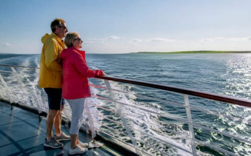 Stelletje geniet op de veerboot van het uitzicht op de Waddeneilanden