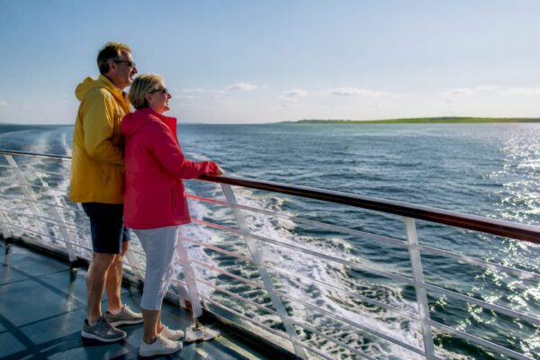 Stelletje geniet op de veerboot van het uitzicht op de Waddeneilanden