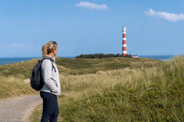 Wandelaars genieten van het strand bij de vuurtoren van Ameland