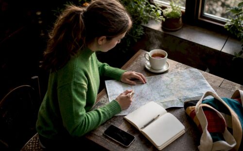 Vrouw bereidt wandelroute voor tijdens koffiemoment in het café