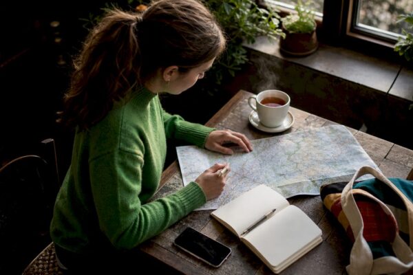 Vrouw bereidt wandelroute voor tijdens koffiemoment in het café