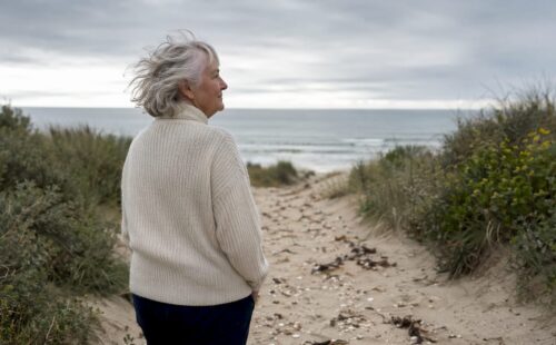 Een vrouw maakt een ontspannen wandeling langs het strand van Ameland.