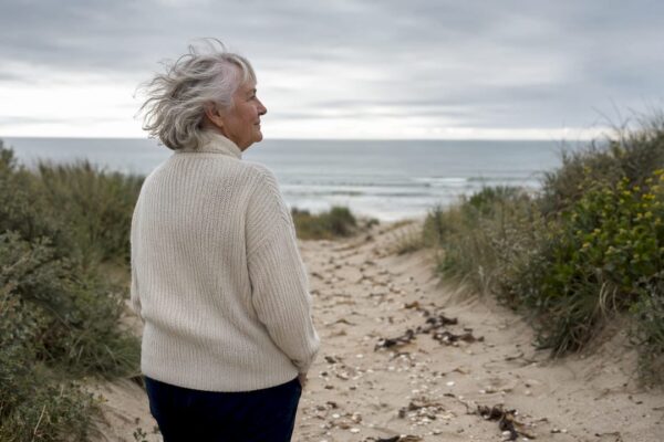 Een vrouw maakt een ontspannen wandeling langs het strand van Ameland.