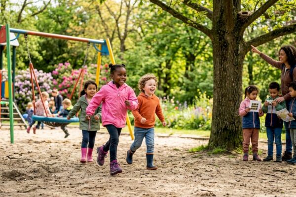 Een groepje kinderen loopt samen met een volwassene over een bospad.