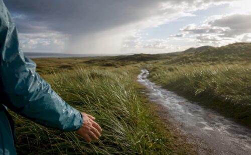 Regenbui trekt over het duinlandschap van Ameland