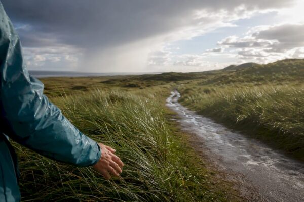 Regenbui trekt over het duinlandschap van Ameland