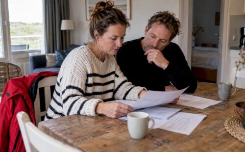 Stel bekijkt reisverzekeringen voor een vakantiewoning
