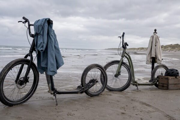 Tieners scheuren met kickbikes over het strand van Ameland