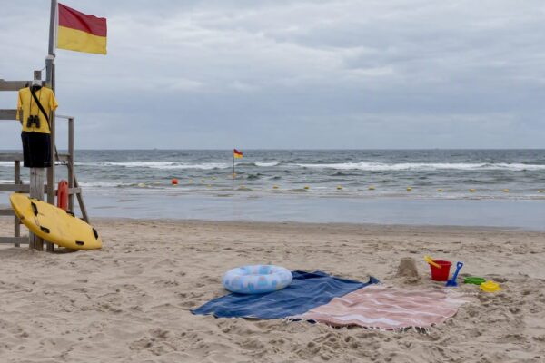 Gezin zwemt binnen het bewaakte zwemgebied op Ameland