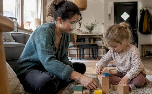 Oppas speelt met kind in het vakantiehuis