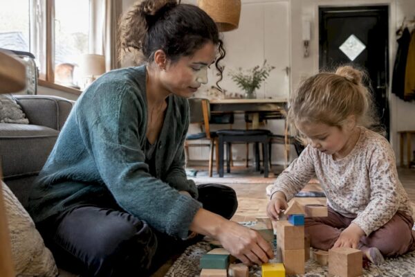 Oppas speelt met kind in het vakantiehuis