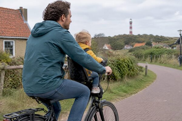 Vader fietst met peuter in een kinderzitje voorop