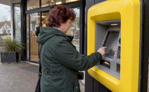 Vrouw haalt geld bij Geldmaat in Nes