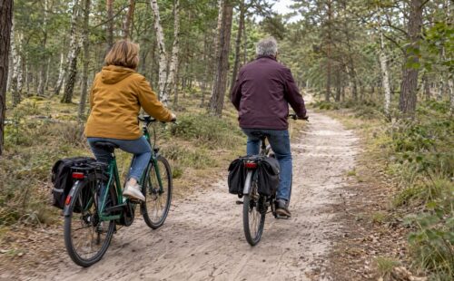 Stel fietst door het bos op Ameland