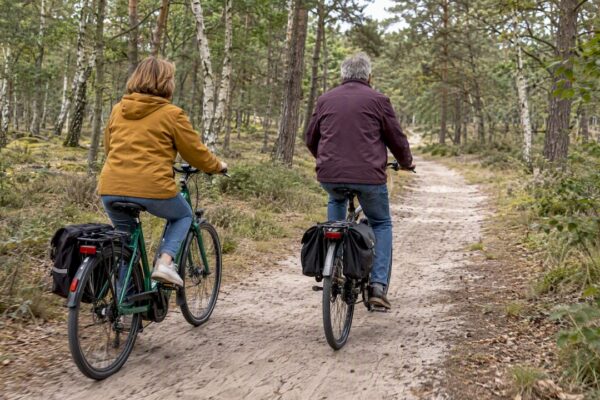 Stel fietst door het bos op Ameland